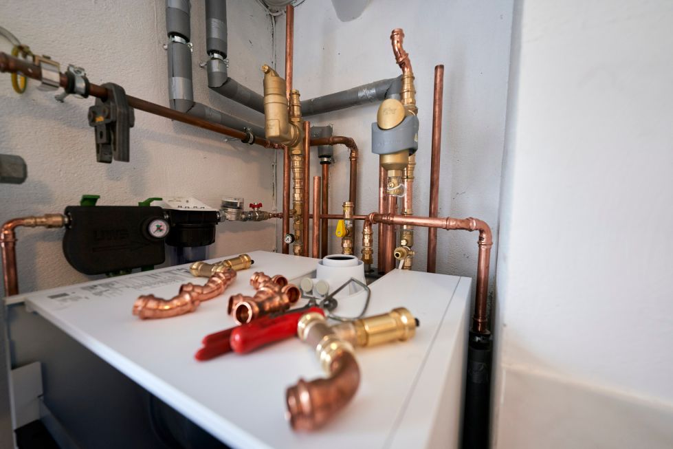 Verschiedene Rohranschlüsse liegen auf einem Heizgerät