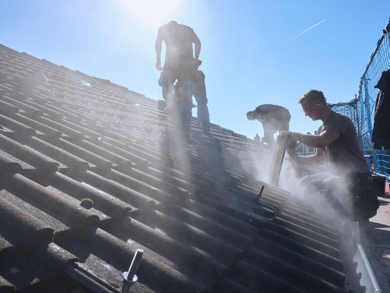 Drei Männer arbeiten auf einem Dach